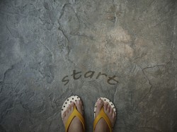A pair of feet floor with word start for the concept of starting point